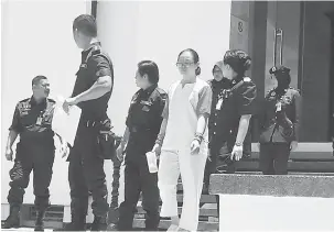  ??  ?? HUKUMAN KEKAL: Yu (tengah) diiringi anggota polis keluar dari kamar Mahkamah Persekutua­n.
