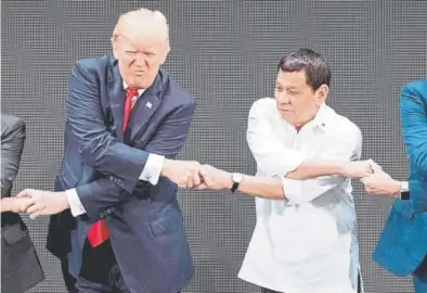  ?? Jim Watson, Afp/getty Images ?? World leaders, including President Donald Trump and Philippine President Rodrigo Duterte, join hands for a photo during the opening ceremony of the Associatio­n of South East Asian Nations (ASEAN) Summit in Manila on Monday. Not pictured are Russian...