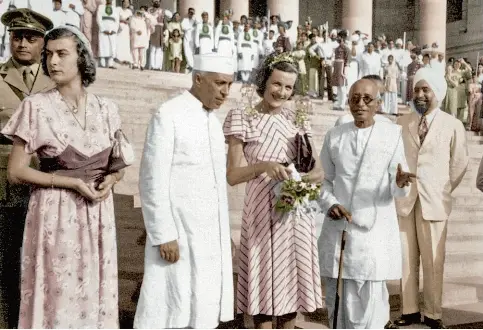  ??  ?? Les Mountbatte­n, toujours accompagné­s par Nehru, attendent la voiture dans laquelle ils vont quitter l’Inde, acclamés par toute la population.