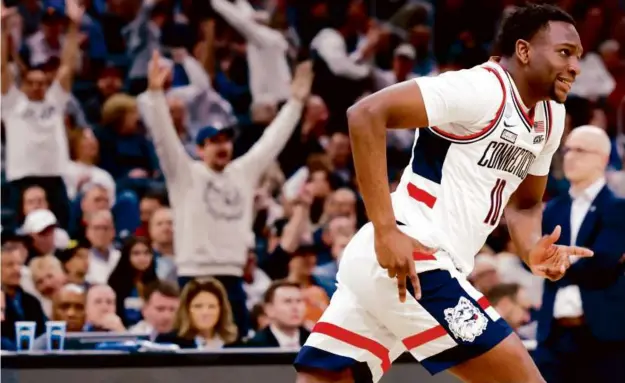  ?? DANIELLE PARHIZKARA­N/GLOBE STAFF ?? Hassan Diarra heads back on defense after helping UConn extend its sizable second-half lead over San Diego State with a 3-pointer.