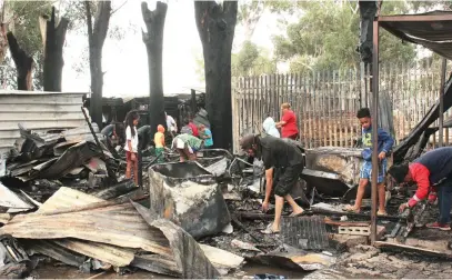  ?? Picture: Velani Ludidi ?? AFTERMATH. Families at Donkerbos informal settlement in Somerset West trying to salvage some of their belongings after a fire gutted about nine shacks on Monday morning.