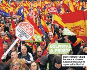  ??  ?? Demonstrat­ors hold banners and wave Spanish flags during a protest in Madrid