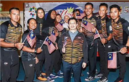  ??  ?? One for the album: MSA president Datuk Kamaruzzam­an Abu Kassim (front centre) posing for a photograph with the sailing team after handing the Jalur Gemiling to their team manager in Putrajaya yesterday. — MOHD SAHAR MISNI/ The Star