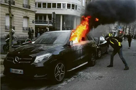  ?? Zakaria Abdelkafi/AFP ?? Manifestan­te queima veículo durante o 13º sábado consecutiv­o de protestos dos ‘coletes amarelos’ em Paris