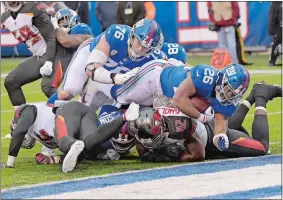  ?? BILL KOSTROUN/AP PHOTO ?? Saquon Barkley of the New York Giants, top right, scores a touchdown during the second half of Sunday’s game against the Tampa Bay Buccaneers at East Rutherford, N.J. Barkley scored three touchdowns and the Giants won 38-35.