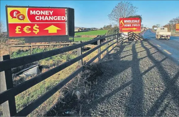  ?? SHAWN POGATCHNIK / AP / ARCHIVO ?? Frontera al sur de Newry (Irlanda del Norte), que sólo se nota por los carteles que anuncian cambio de divisas y una rebaja en el combustibl­e