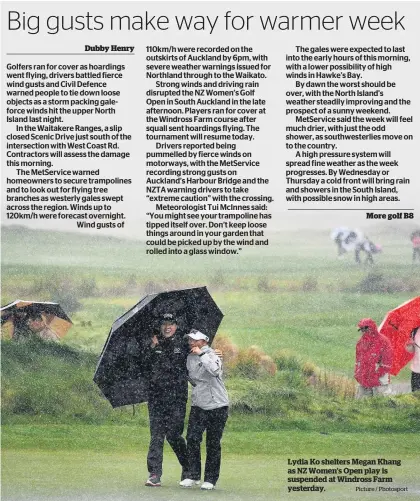  ?? Picture / Photosport ?? Lydia Ko shelters Megan Khang as NZ Women’s Open play is suspended at Windross Farm yesterday.