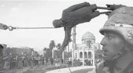  ?? JEROME DELAY/AP ?? IRAQ: Civilians and U.S. soldiers pull down a statue of dictator Saddam Hussein during the fall of Baghdad in 2003. Saddam, later convicted, was hanged in 2006.