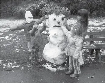  ?? Clem Albers / The Chronicle 1976 ?? Kids fashion a snowwoman out of the white stuff and twigs in Golden Gate Park on the snow day.