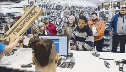  ?? AP ?? The first customers at Superior Firearms in Texas line up to pay for their purchases just after 7 a.m. on Black Friday.