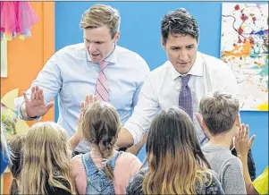  ?? THE CANADIAN PRESS/ANDREW VAUGHAN ?? Prime Minister Justin Trudeau, right, and New Brunswick Premier Brian Gallant greet children as they visit Wee College daycare and early learning centre in Moncton, N.B., on Wednesday.