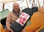  ?? CHRIS TOBIN/STUFF ?? Pilot Russell Brodie takes the poppy and star artworks from his Tiger Moth after flying to Timaru yesterday.