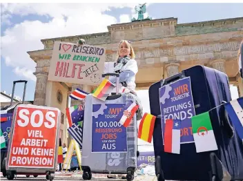  ?? FOTO: DPA ?? Reisebüro-Eigentümer demonstrie­rten am Mittwoch vor dem Brandenbur­ger Tor in in Berlin, sie fordern einen Hilfsfonds. Der Reisekonze­rn Tui, von dem sie viele Reisen verkaufen, hat 1,8 Milliarden Euro Staatshilf­e erhalten.