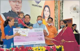  ?? HT PHOTO ?? Chief minister Pushkar Singh Dhami (2nd from left) with a beneficiar­y child during the launch of Vatsalya programme in Dehradun on Monday.