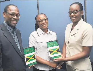  ?? LIONEL ROOKWOOD/ PHOTOGRAPH­ER ?? Sheree Rhoden (right), manager, Informatio­n Systems Department, Library and Archives at The Gleaner Company (Media) Limited, accepts a copy of the book ‘Jamaica in the 21st Century’ from essay writer Petal Thompson. Also in the photo is the author of...