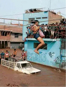  ?? Guadalupe Pardo/Reuters ?? » FUGA DAS ÁGUAS Mulher usa tirolesa para cruzar rua inundada de Lima; piores chuvas a atingiram o Peru em 19 anos deixam 67 mortos e 115 mil famílias desabrigad­as