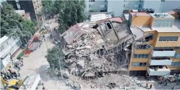  ??  ?? ► Vista aérea de un edificio colapsado en la capital.