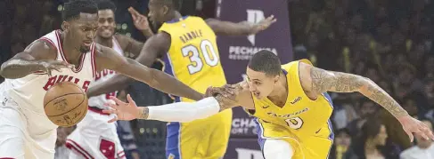  ?? AP ?? Los Angeles Lakers forward Kyle Kuzma, right, tries to steal the ball from Chicago Bulls forward Bobby Portis during the second half of an NBA game in Los Angeles. The Lakers won 103-94.