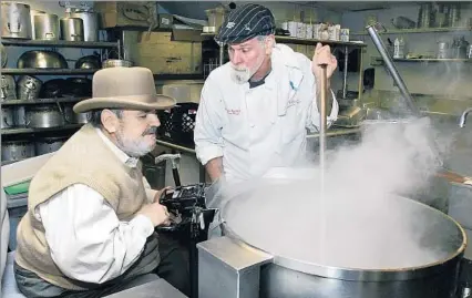  ?? Bill Haber ?? SHARING TRADITION Chef Paul Prudhomme, left, with Cannon Wiest at K-Paul’s Louisiana Kitchen in New Orleans in 2007, introduced the nation to Cajun cooking with dishes like gumbo and blackened redfish. The youngest of 13 children, he learned to cook at...