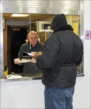  ?? TAWANA ROBERTS — THE NEWS-HERALD ?? Homeless Program Coordinato­r Steve Jacobs serves hot meals at the Salvation Army of Painesvill­e on Dec. 28.