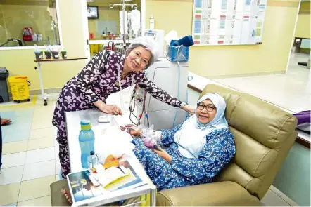  ??  ?? Prof Emeritus Kong (left) visiting a CKD patients on dialysis at one of the MAA Medicare Charity Dialysis Centres.