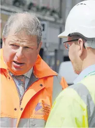  ??  ?? DANGER: Inverness city centre manager David Haas, talks to a building officer in Church Street after debris, below, fell from a roof and hit two tourists in High Street, bringing the emergency services to the scene