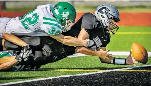  ?? JIM WEBER/THE NEW MEXICAN ?? Jaguars quarterbac­k Julian Muñoz, right, is tackled by Moriarty’s Erik Wolf as he stretches into the end zone for a touchdown during Capital High School’s 35-34 win over Moriarty on Saturday at Capital.