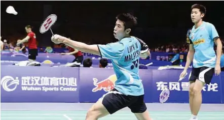  ??  ?? Strong debut: Lim Khim Wah (left) and Goh V Shem in action against South Africa’s Dorian Prakash Viyajanath-jacob Malieka during their Thomas Cup Group C match at the Wuhan Sports Centre yesterday. The Malaysian pair won 21-11, 21-14.