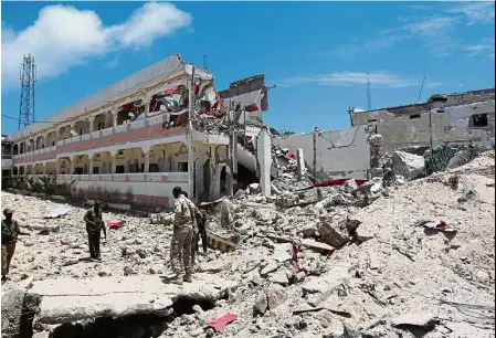  ??  ?? Extensive damages: security forces standing at the syL hotel that was partly destroyed following a car bomb claimed by al shabaab militants outside the president’s palace in the somali capital of Mogadishu. — Reuters