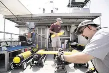  ?? Johnny Hanson / Houston Chronicle ?? Marine technician Andrew Dancer, right, and Steve DiMarco, a Texas A&Moceanogra­phy professor, work on an Acrobat towed underwater vehicle.