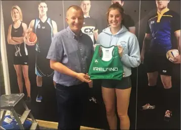  ??  ?? St Gerard’s AC’s Kate O’Connor, who will represent Ireland, receives her new kit from David Minto.