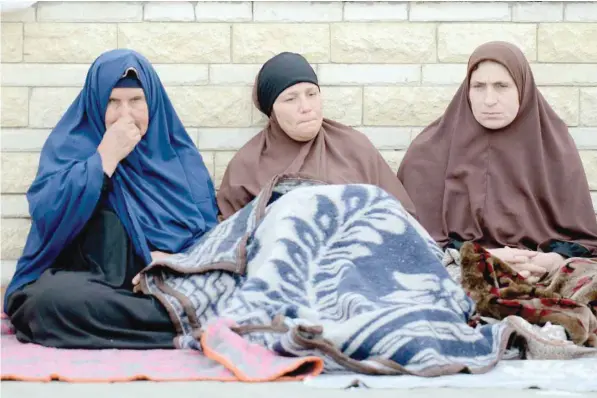  ?? — AFP ?? Relatives of the victims of the bomb and gun assault on the North Sinai Rawda Mosque sit outside the Suez Canal University Hospital in the eastern port city of Ismailia on Saturday.