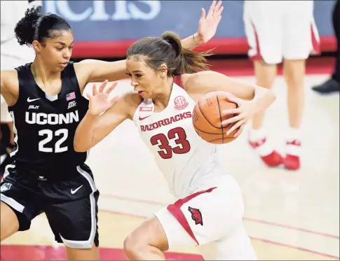  ?? Michael Woods / Associated Press ?? Arkansas guard Chelsea Dungee (33) tries to drive past UConn defender Evina Westbrook during the first half in January.