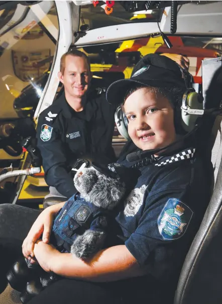  ?? Picture: GLENN HAMPSON ?? Senior Constable Geoff Harris shows the PolAir helicopter to ‘Cop for a Day’ Alana Cassells, 6.