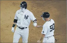 ?? FRANK FRANKLIN II ?? New York Yankees’ Clint Frazier (77) fist bumps first base coach Reggie Willits (50) after hitting a two-run single during the seventh inning of a baseball game Saturday, Aug. 15, 2020, in New York.