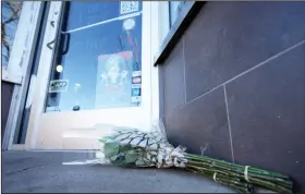  ?? (AP/David Zalubowski) ?? Bouquets of flowers are placed outside the door of a tattoo parlor along South Broadway on Tuesday in Denver. Video at arkansason­line.com/1229denver/.