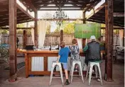  ?? ?? Wyatt and Winston Loy watch football with their grandfathe­r, Larry, at Larson Family Winery.