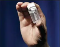  ?? JACQUELYN MARTIN — THE ASSOCIATED PRESS ?? A reporter holds up an example of the amount of fentanyl that can be deadly after a news conference about deaths from fentanyl exposure, at DEA Headquarte­rs in Arlington Va., Tuesday.