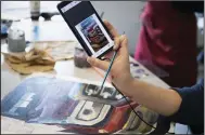  ?? (River Valley Democrat-Gazette/Charlie Kaijo) ?? Jocelyn Cordero holds up a picture of a car she’s painting in her art class Friday at the Haas Hall campus in Rogers. Visit nwaonline. com/photos for today’s photo gallery.