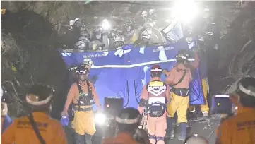  ??  ?? Firefighte­rs carry a missing person found from an area damaged by a landslide caused by an earthquake. — Reuters photo