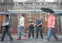  ?? DREW ANGERER/GETTY IMAGES ?? New York police guard the New York Times on Thursday after increased security was mandated at major media companies.