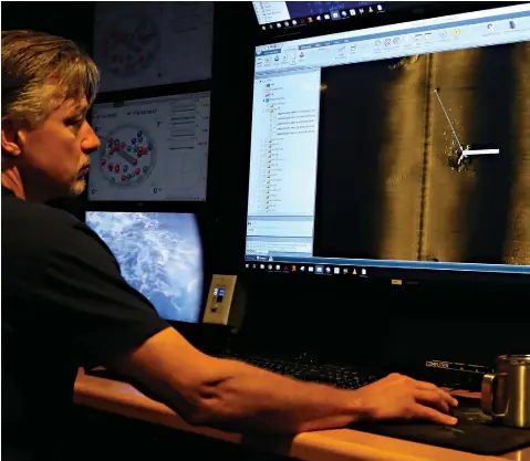  ?? Associated Press ?? ■ Rob Kraft, director of undersea operations at Vulcan Inc., reviews sonar scans of a warship from the World War II Battle of Midway that was found by Sunday by the crew of the research vessel Petrel off Midway Atoll in the Northweste­rn Hawaiian Islands.