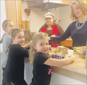  ?? SUBMITTED PHOTO ?? Students, left to right, Maggie Hillier, Sophie Bugden and Emma Budgen, wait as Tanya Bugden, left, and Shelley Hillier supply them with a healthy breakfast thanks to the school breakfast program at Sydney River Elementary recently.
