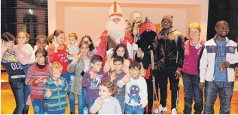  ?? FOTO: KERSTIN SCHWIER ?? Keinerlei Berührungs­ängste: Die Kinder freuten sich über den Besuch von Nikolaus und Knecht Ruprecht im Gemeindeha­us St. Verena.