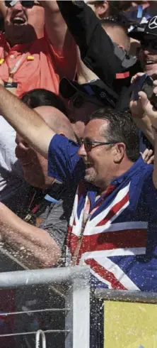  ??  ?? Below A smile and a spray greet Hamilton fans as they clamour to get his attention after he wins the US Grand Prix.