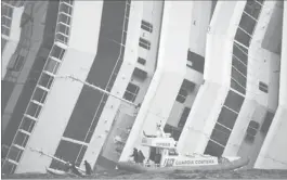  ??  ?? RESCUERS stand in a boat next to the Costa Concordia cruise ship yesterday. — Reuters