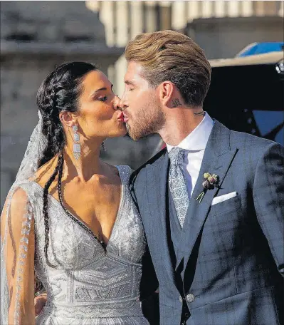  ??  ?? Pilar Rubio y Sergio Ramos se besan, a la salida de la ceremonia en la catedral de Sevilla.