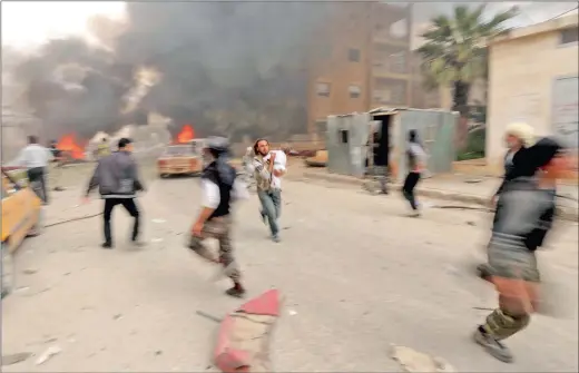  ?? PICTURE: AMMAR ABDALLAH / REUTERS ?? UNDER CONSTANT THREAT: A man runs with an injured child at a damaged site after what activists said was shelling by forces loyal to Syria’s president Bashar al-Assad on a neighbourh­ood in Idlib city, after rebels took control of the area in April. The...