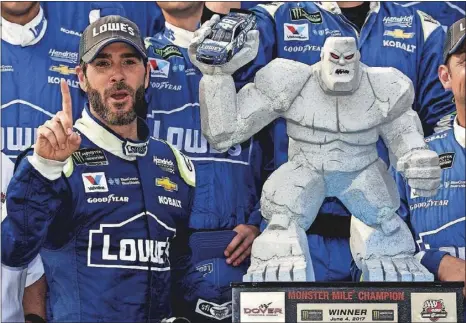  ?? [AP/NICK WASS] ?? Jimmie Johnson poses with the Dover trophy (“Miles the Monster”) after earning his 83rd career Cup victory, tying him with Cale Yarborough on the all-time win list.