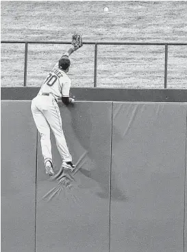  ?? Brandon Wade / Associated Press ?? A valiant effort by Astros center fielder Carlos Gomez fails to prevent a home run hit by the Rangers’ Bobby Wilson in the fifth inning.